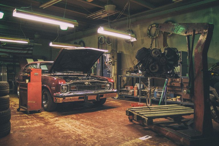 American coupe in a quiet workshop with an engine on the hoist